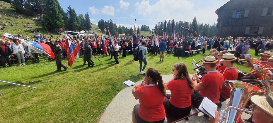 Fotografija: Pri planinskem domu na Menini planini so plapolali številni prapori domoljubnih društev. FOTO: Bojan Rajšek