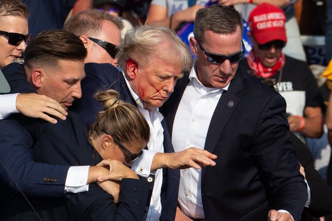 Obkrožen z agenti, ki so ga pospremili na varno. FOTO: Rebecca Droke Afp