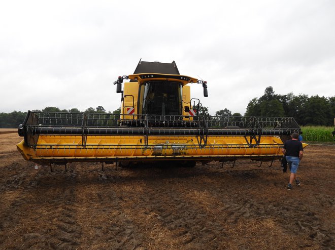 Žitni kombajn new holland CR 8.80 z žetvenim ustjem, širokim 8,53 metra. Model ima vgrajen motor s 380 kW (517 KM) moči, zalogovnik za seme ima 12.500 litrov prostornine. Kombajn ima aksialno mlatilno napravo z dvema rotorjema twin rotor. Vgrajene ima številne inovativne asistenčne funkcije, kot so dynamic flow control™, daljinsko nastavljive lopatice rotorja, tehnologija dynamic feed roll™ in patentirani superširoki trosilni sistem opti-spread™ plus. Seveda pri najsodobnejših strojih ne gre več brez satelitske navigacije, ki omogoča tudi izdelavo kart pridelka, vodenje po vodilnih linijah, celotno telemetrijo itd. FOTO: Tomaž Poje