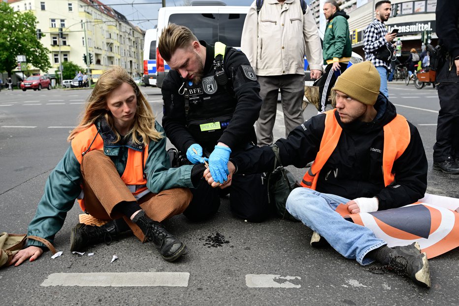 Fotografija: Aktivisti Zadnje generacije se zalepijo na tla. FOTO: Afp