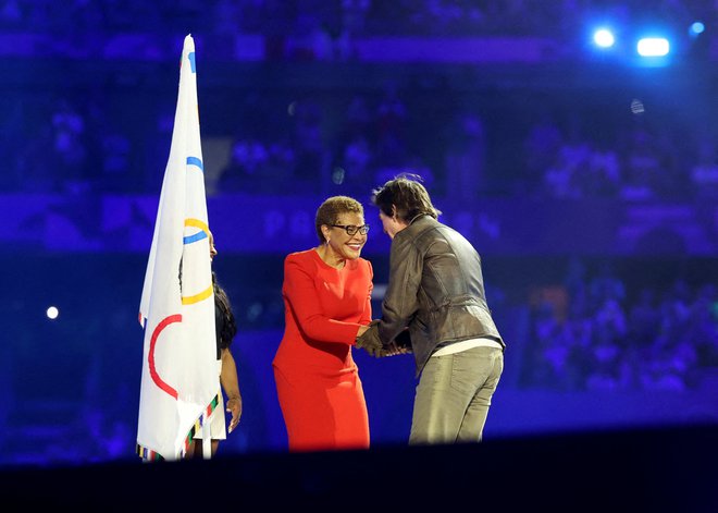 Županja Los Angelesa Karen Bass je predala olimpijsko zastavo Tomu Cruisu, ta jo je z motorjem in letalom odnesel v Los Angeles. FOTO: Phil Noble/Reuters