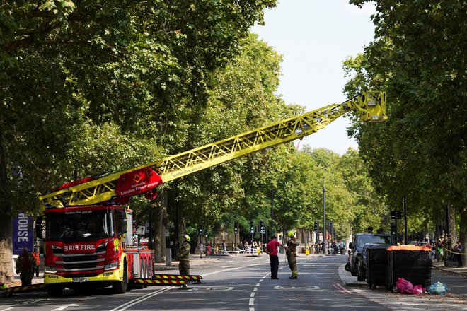 Gasilci pred hišo Somerset. FOTO: Maja Smiejkowska Reuters