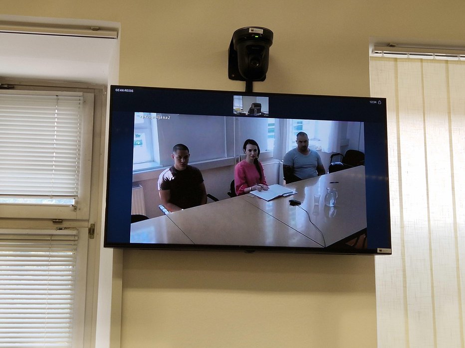 Fotografija: David Bakić in Miroslav Mirković sta se iz pripora javila prek videokonference, med njima prevajalka. FOTO: Tanja Jakše Gazvoda