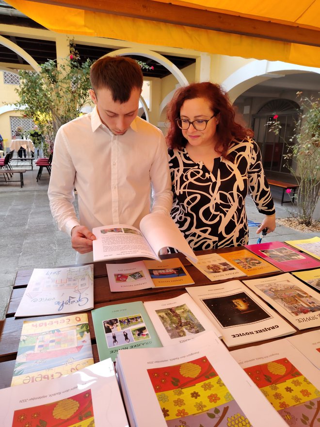 Danijel med prebiranjem Grajskih novic, ki jih ustvarjajo sami. FOTO: Mojca Marot