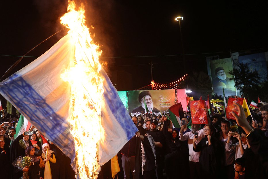 Fotografija: Iranci v Teheranu zažgejo izraelsko zastavo med praznovanjem napada na Izrael. FOTO: Majid Asgaripour Via Reuters