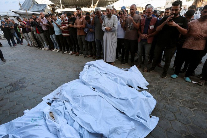 Žalujoči ob truplih Palestincev, ki so bili ubiti v izraelskih napadih v Gazi 2. oktobra. FOTO: Ramadan Abed Reuters