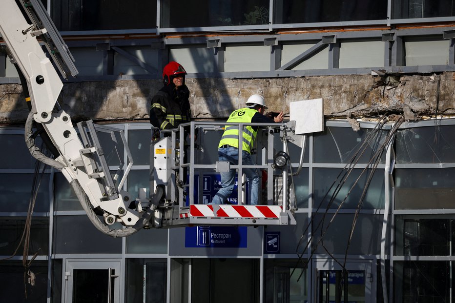 Fotografija: Reševalna ekipa pregleduje območje, kjer se je zrušil del strehe železniške postaje v Novem Sadu. FOTO: Marko Djurica Reuters