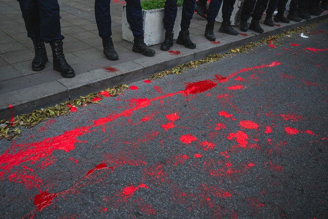 Rdeča barva pred ministrstvom za gradbeništvo, promet in infrastrukturo v Beogradu, 3. novembra 2024. Tja so jo vrgli demonstranti v znak vladnega zanemarjanja in slabega upravljanja infrastrukture. FOTO: Andrej Isakovic Afp