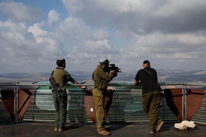 Izraelski vojak gleda skozi daljnogled puške iz Izraela v južni Libanon, 4. november 2024. FOTO: Violeta Santos Moura Reuters