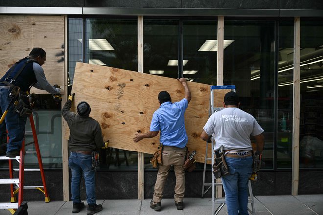 Prostore poskušajo zaščititi z lesom. FOTO: Brendan Smialowski/Afp