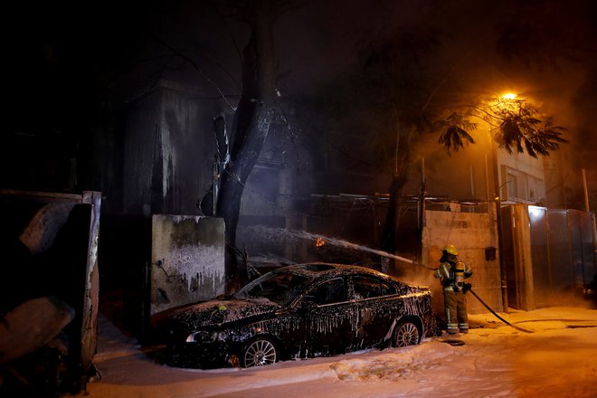 Gasilec na prizorišču, kamor je padel projektil, ki so ga izstrelili iz Libanona, v Kirjat Ati na severu Izraela, 11. novembra 2024. FOTO: Shir Torem Reuters