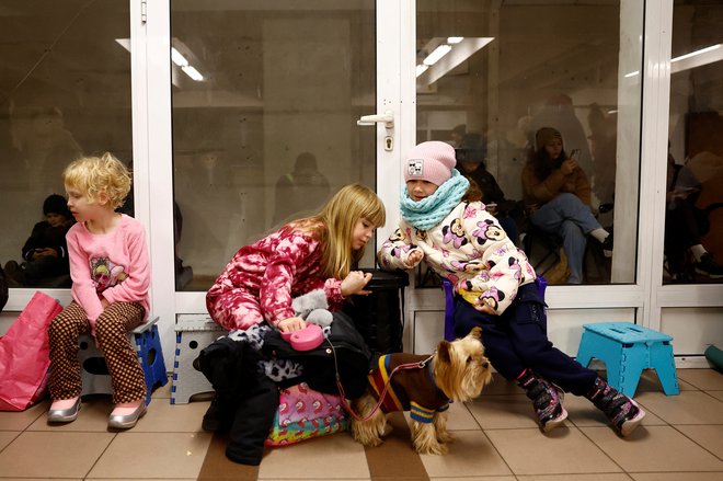 Otroci s psom se skrivajo med napadom ruskih raket in brezpilotnih letal v Kijevu, 13. novembra 2024. FOTO: Alina Smutko Reuters