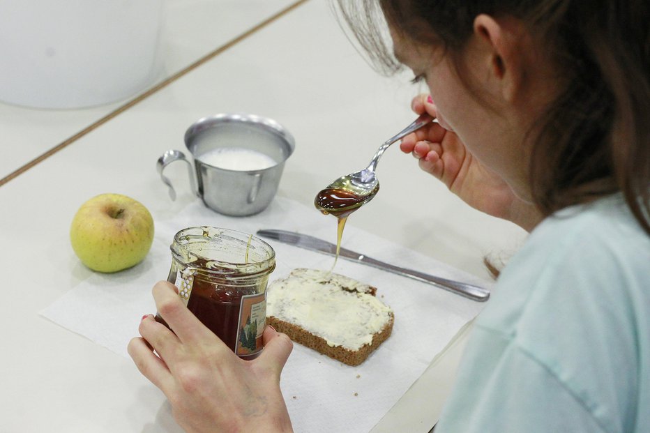 Fotografija: Že 18. leto so se otroci mastili s tradicionalnim slovenskim zajtrkom. Pravi med ni le okusen, ampak tudi izjemno koristen za zdravje. FOTO: Leon Vidic