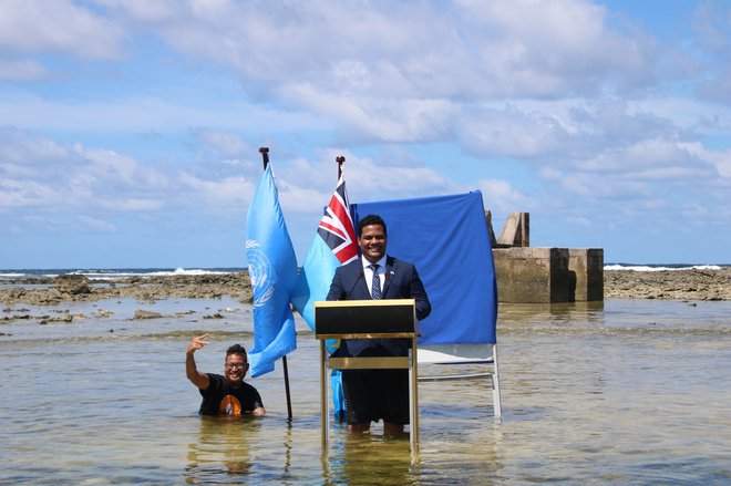 Zunanji minister Tuvaluja Simon Kofe je udeležence konference nagovoril stoječ v oceanu. FOTO: Reuters