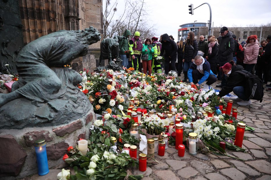 Fotografija: Ljudje na prizorišče tragedije že od jutra prinašajo cvetje in sveče. FOTO: Ronny Hartmann/Afp