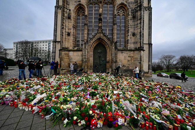 Pred magdeburško cerkev so mnogi prinesli cvetje in prižigali svečke v spomin na žrtve. FOTO: John Macdougall/Afp