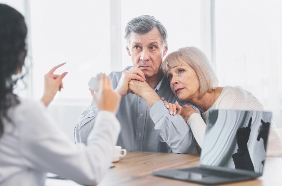 Fotografija: Prescription Concept. Female doctor holding jar of pills, giving instructions to sad senior couple at office, copyspace FOTO: Prostock-studio Getty Images