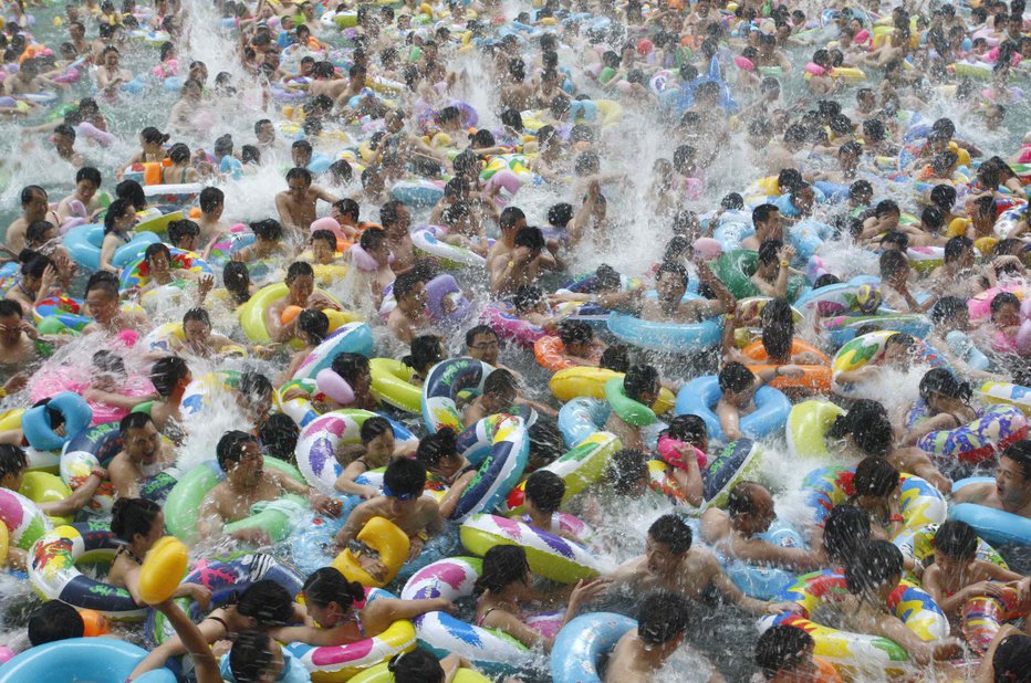 Fotografija: Domačini pred vročino množično bežijo v bazene in kopališča. FOTO: Stringer Shanghai/Reuters