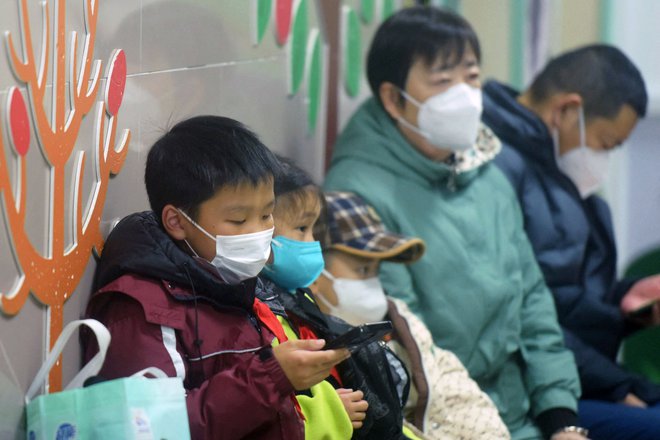 Zamaskirani otroci, ki jih spremljajo odrasli, čakajo na pregled zdravstvenega osebja na pediatričnem oddelku bolnišnice v mestu Hangzhou vzhodu Kitajske, 6. januarja 2025. FOTO: Str Afp