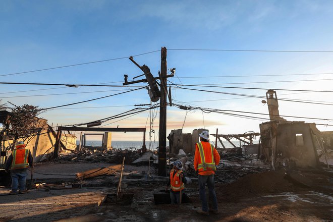 Delavci poskušajo zavarovati poškodovane električne daljnovode, ki jih je uničil požar Pacific Palisades. FOTO: Valerie Macon Afp