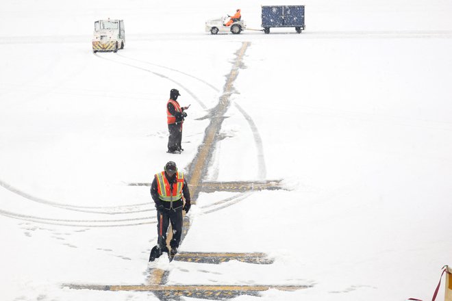 Delavci odstranjujejo sneg, ki je prekril letališče Hartsfield-Jackson v Atlanti. FOTO: Joe Raedle Getty Images Via Afp