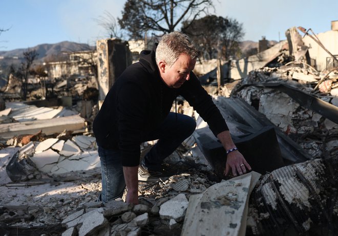 Pastor John Shaver se prvič po požaru povzpne skozi ruševine cerkve Community United Methodist, ki je bila uničena v požaru. Poleg cerkve je izgubil tudi svoj dom, vendar kljub temu načrtuje obnovo cerkve. FOTO: Mario Tama Getty Images Via Afp