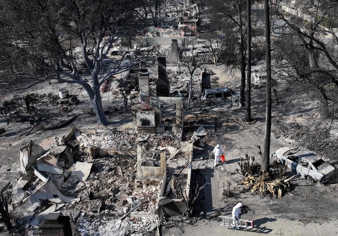 Par v soseski Altadena išče ostanke svoje hiše, ki je zgorela v požaru Eaton. FOTO: Mario Tama Getty Images Via Afp