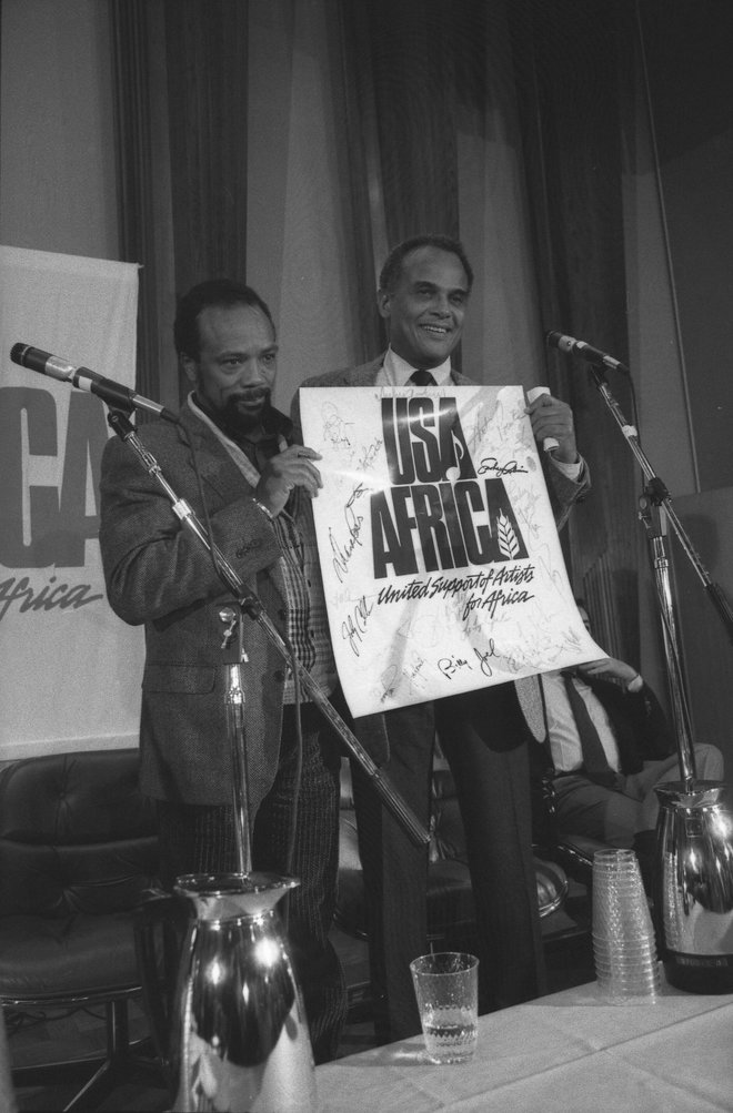 Producent Quincy Jones in idejni oče projekta Harry Belafonte s posterjem ZDA za Afriko in podpisi sodelujočih glasbenikov FOTO: Randy Leffingwell/Los Angeles Times/Wikimedia Commons CC BY 4.0