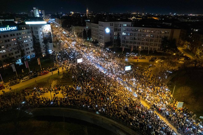 Fotografija iz zraka prikazuje demonstrante, ki med 15-minutnim molkom v Novem Sadu 31. januarja 2025 svetijo s svojimi telefoni. FOTO: Nenad Mihajlovic Afp